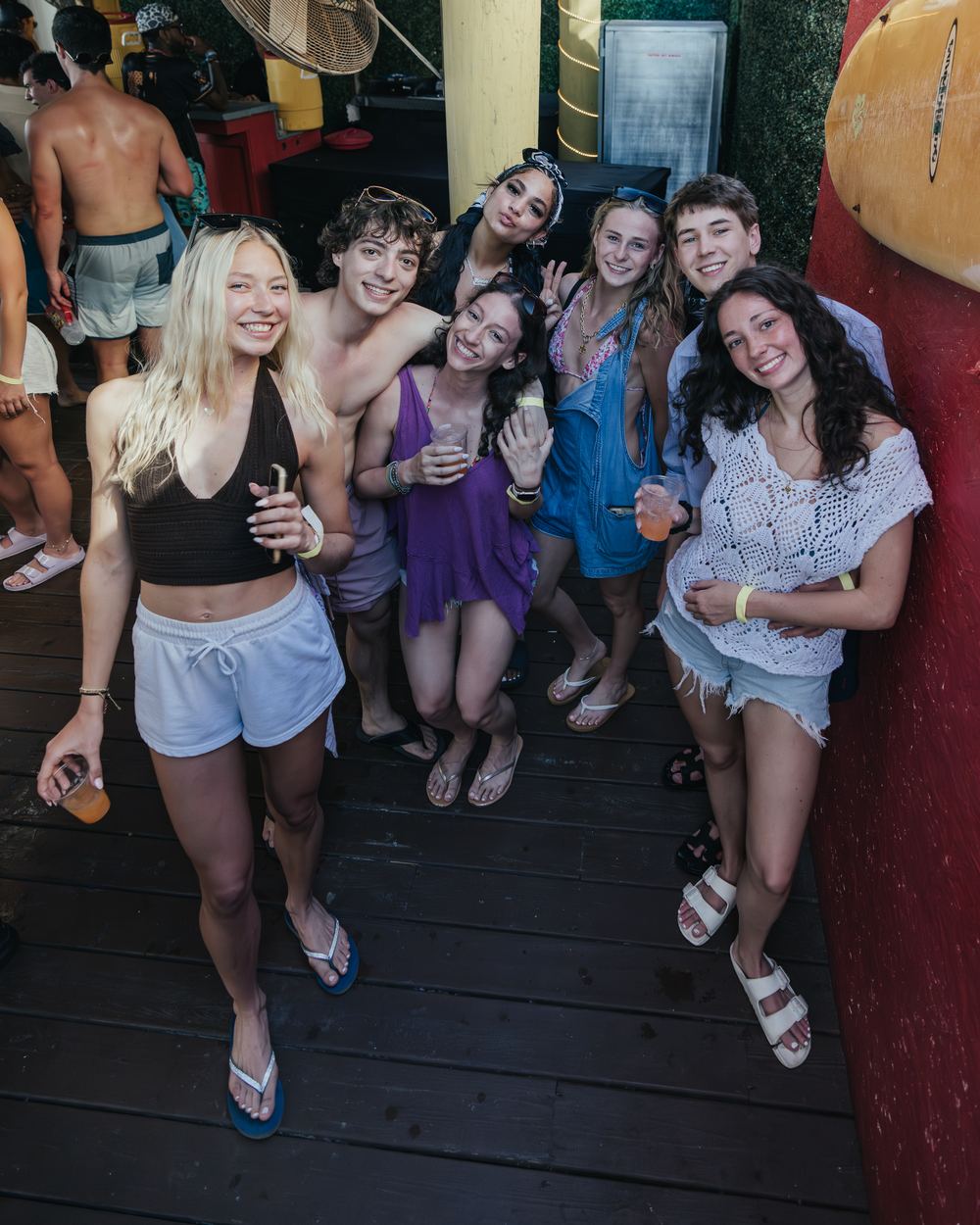 A group of nine friends posing together on the deck at Señor Frog's during a spring break day party in Panama City Beach
