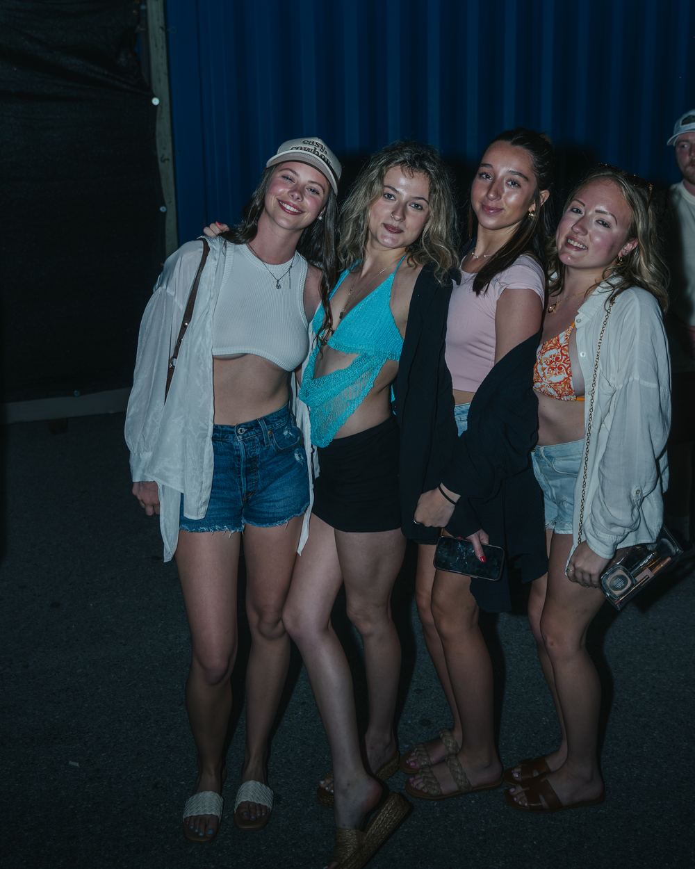 Four friends posing arm in arm outside a venue on a spring break night in Panama City Beach