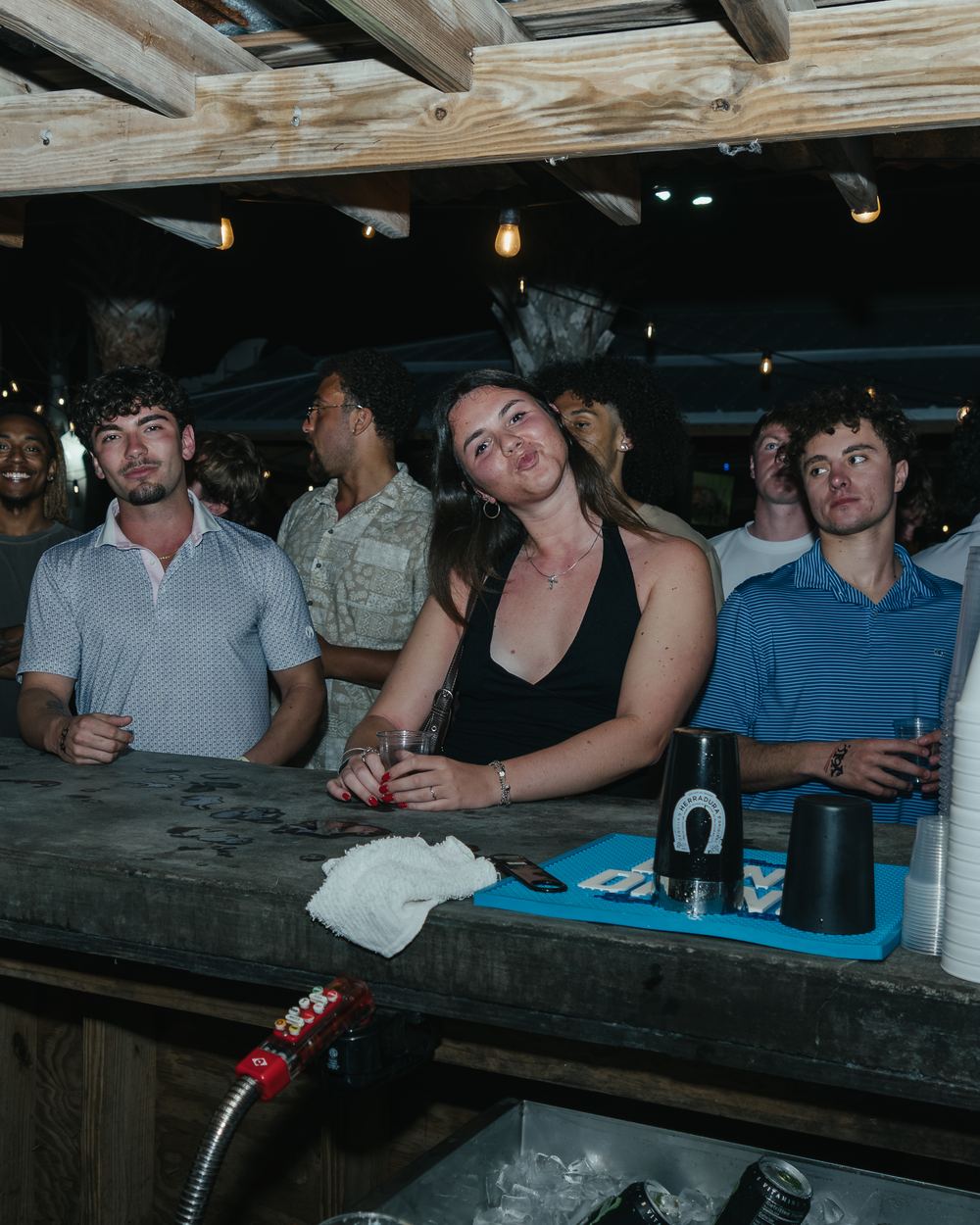 Friends lined up at an outdoor bar on a spring break night in Panama City Beach