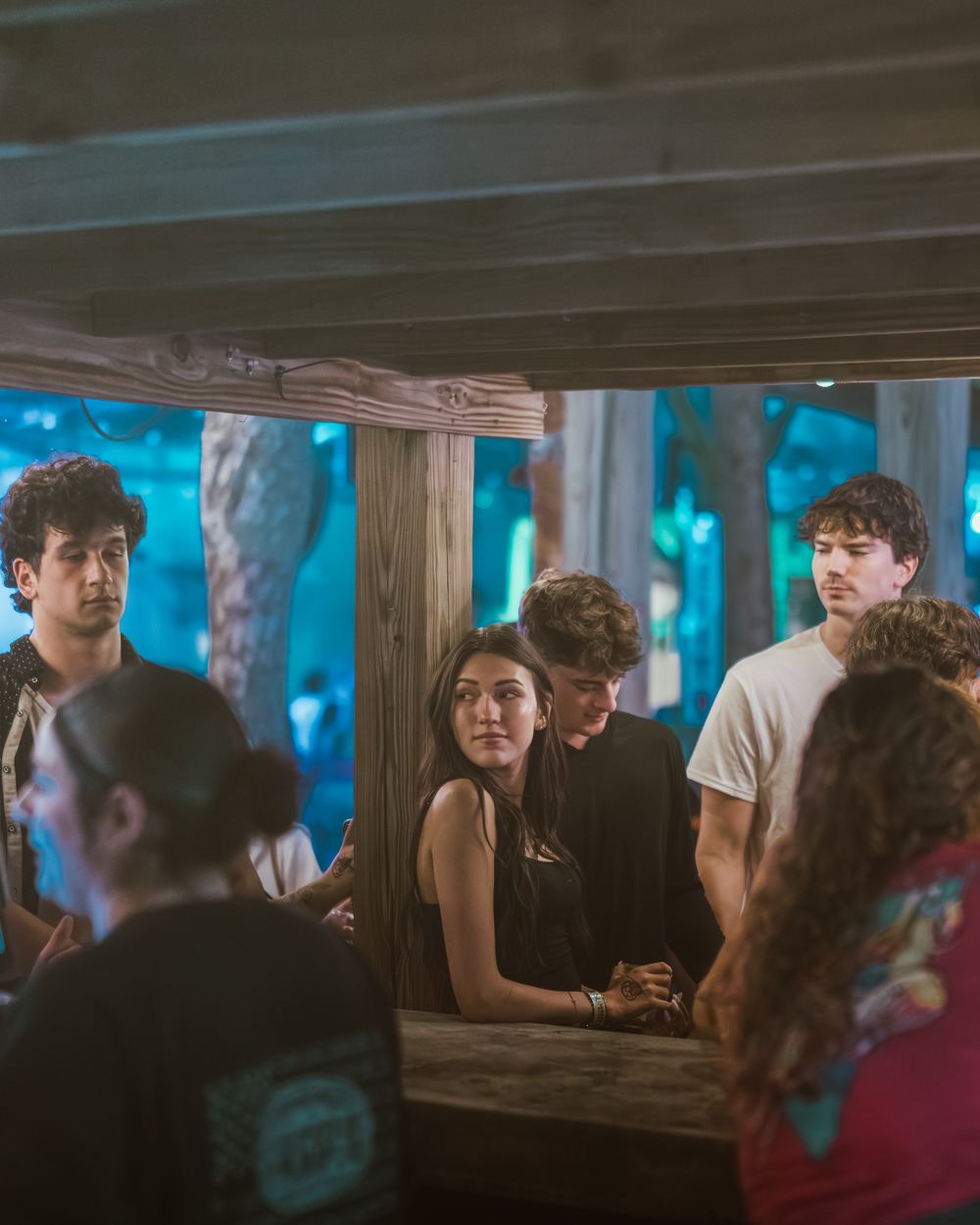 Friends hanging out around a wooden bar on a spring break night in Panama City Beach