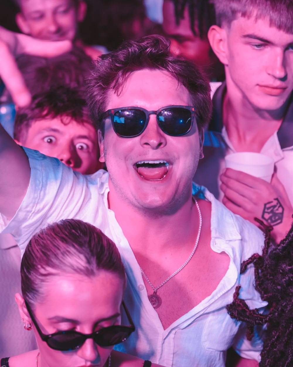 Friends in sunglasses cheering in the crowd at a Panama City Beach spring break party
