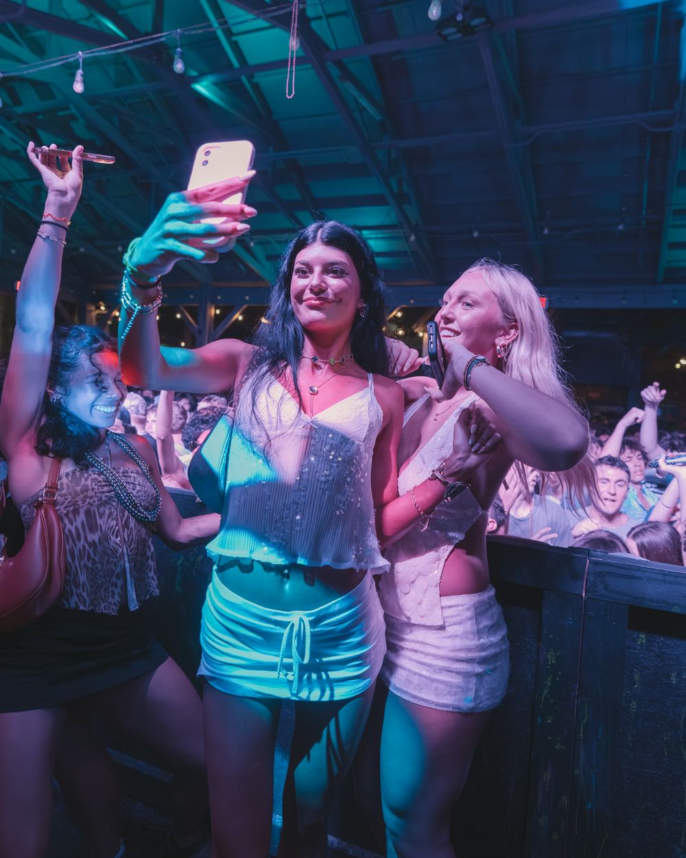 Friends taking a selfie with their phones at a Panama City Beach spring break party