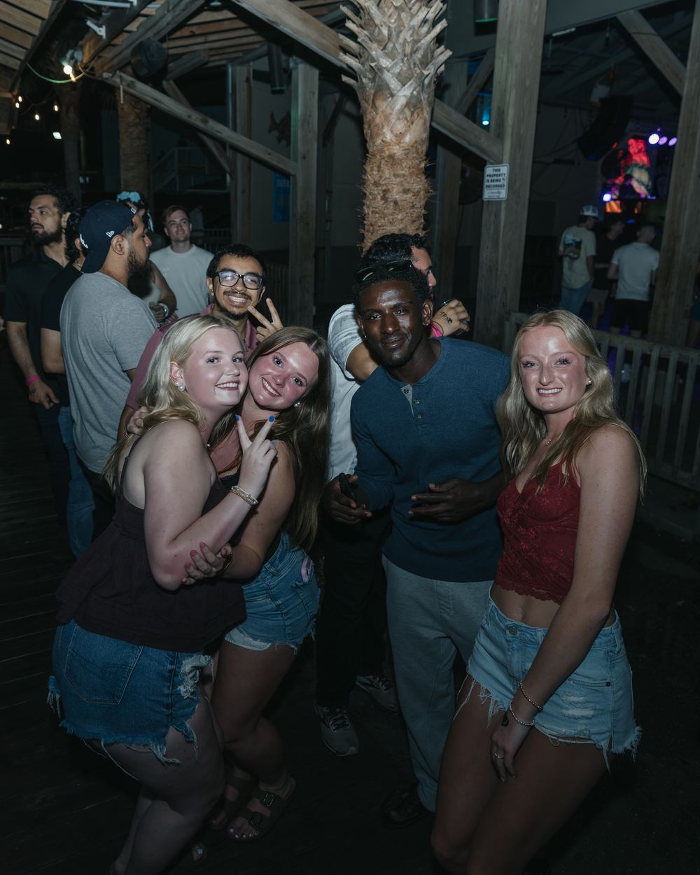Five friends huddled together for a photo on a spring break night out in Panama City Beach