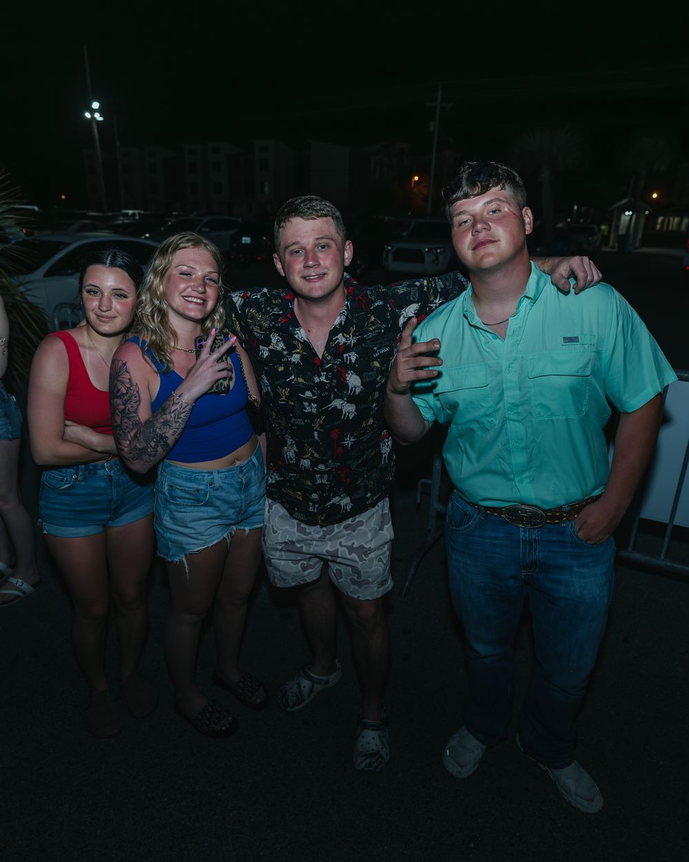 Two women and two men posing together outside at night during spring break in Panama City Beach